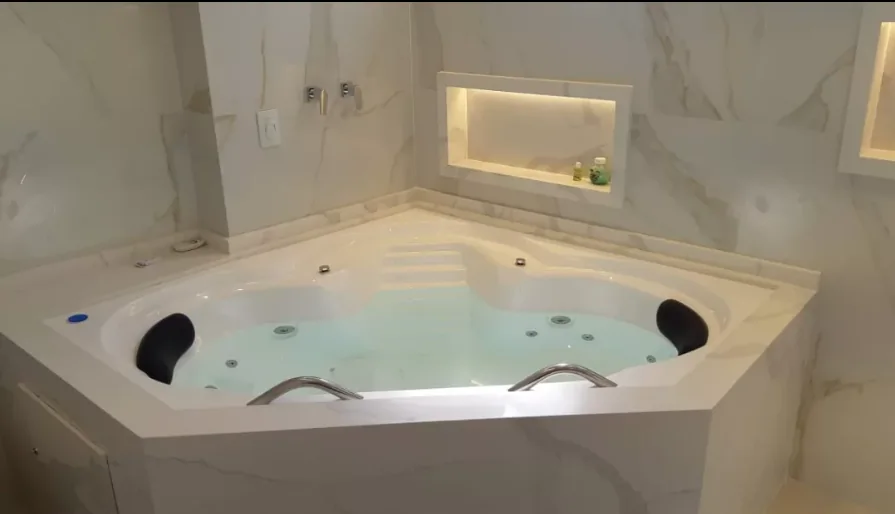 Banheira de hidromassagem revestida em mármore branco, obra da Completa