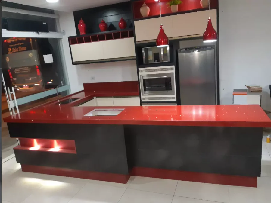 Ilha em quartzo vermelho com base preta, obra da Completa